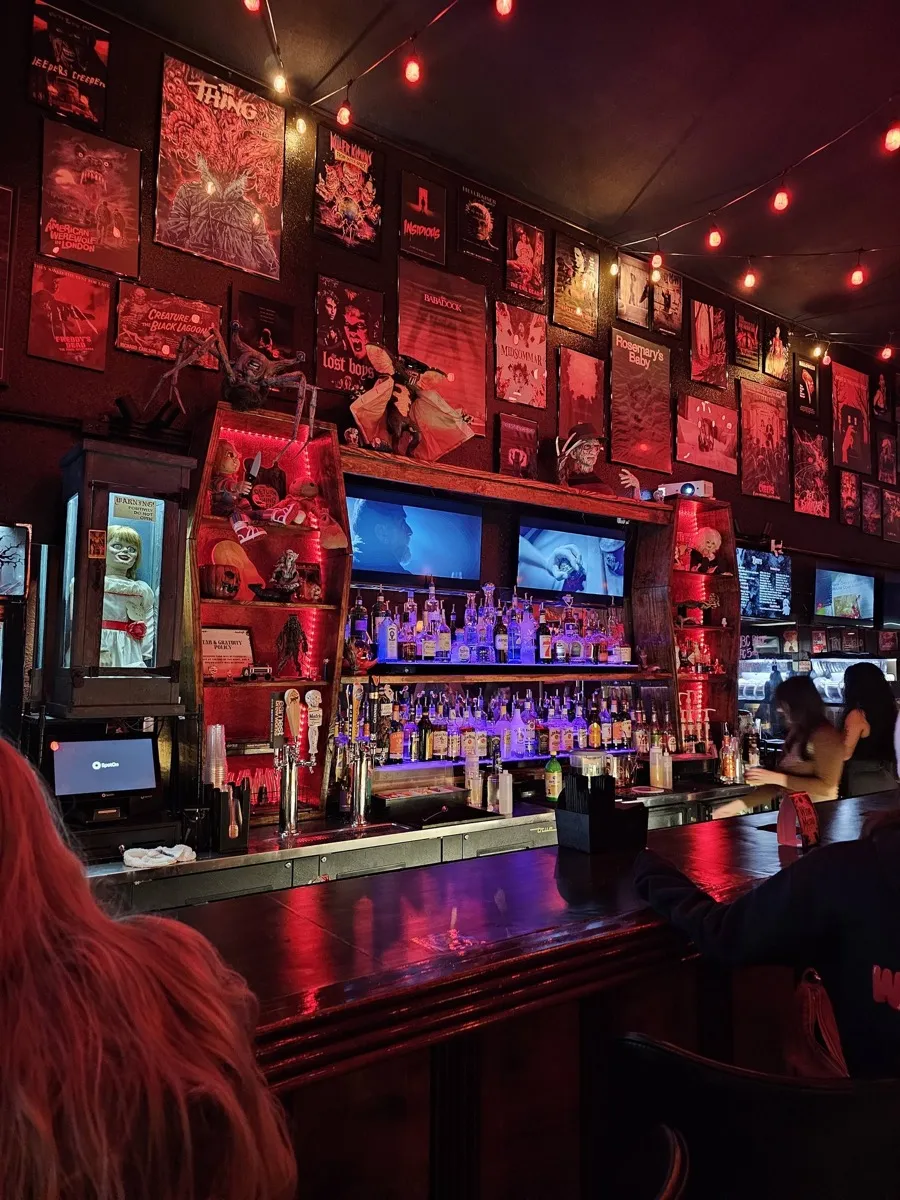 Bar interior with horror posters and red lighting